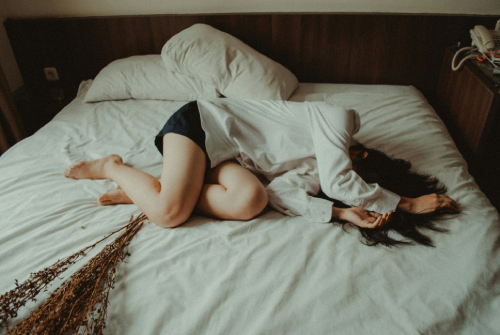 Depressed woman laying in bed not wanting to get up