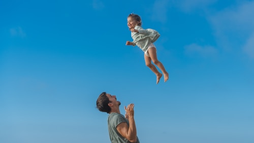 a man and a little girl flying through the air